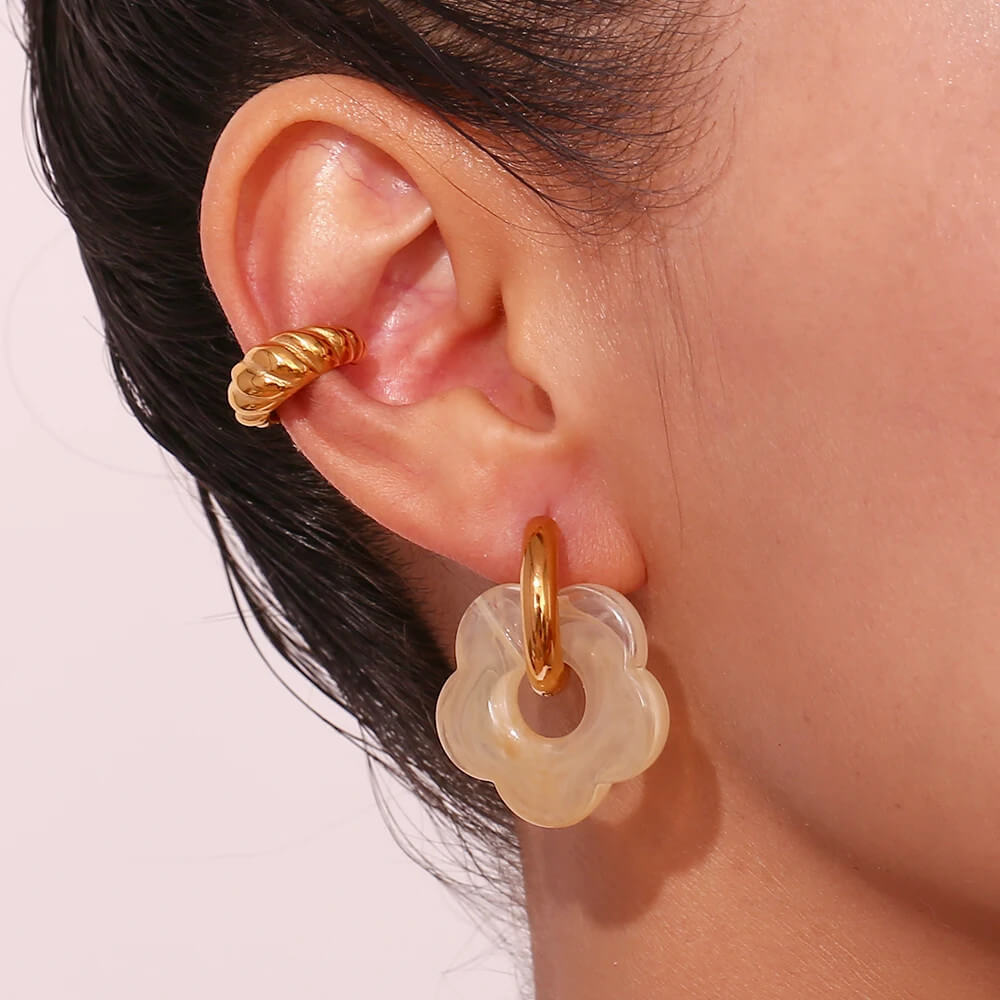 A model wearing the Acrylic Gold Flower Earrings.