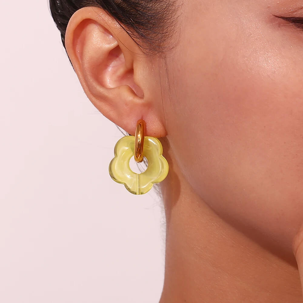 A woman wearing Acrylic Gold Flower Earrings.