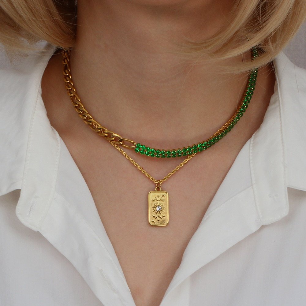 A model wearing multiple gold necklaces.