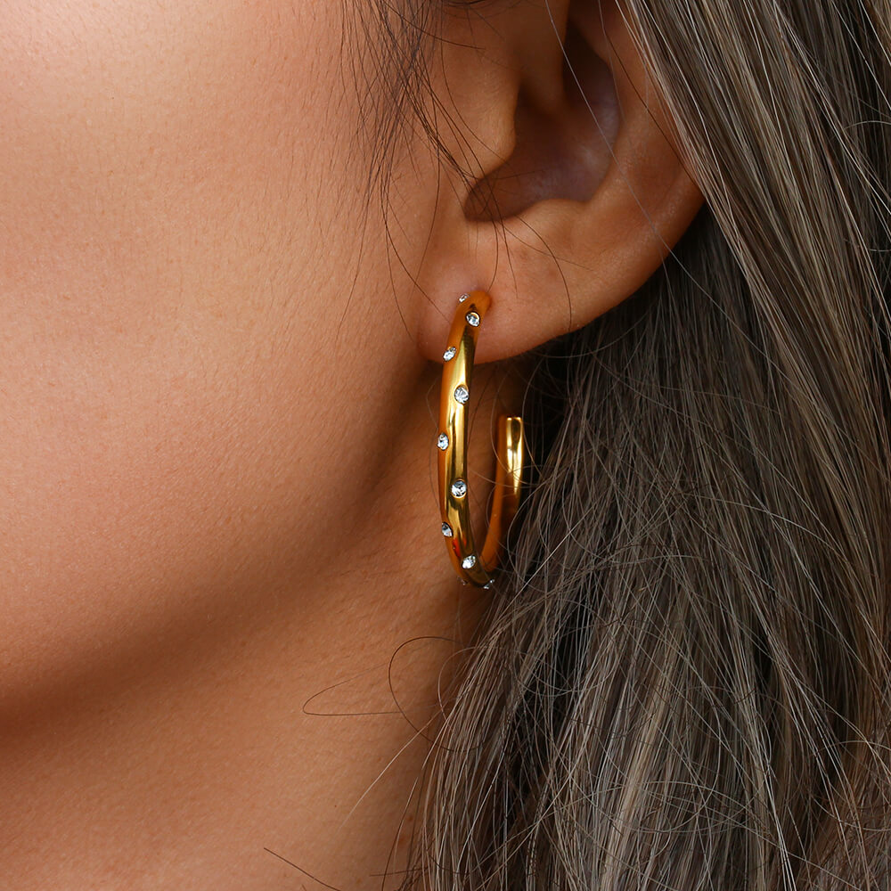 A woman wearing the Galaxy Gold Hoops.