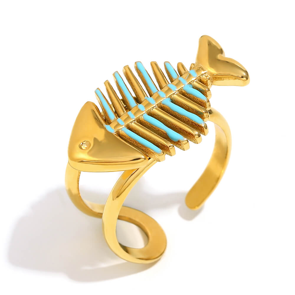 Gold fish bone skeleton ring with turquoise bones on a white background.