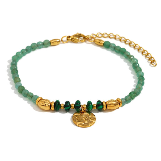 Green and gold beaded bracelet on white background.