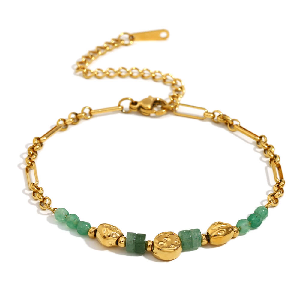 Gold bracelet with green beads on a white background.
