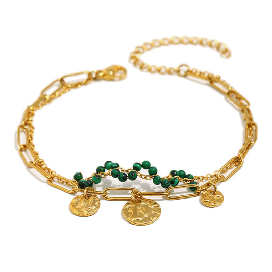 Gold chain and coin bracelet on white background.