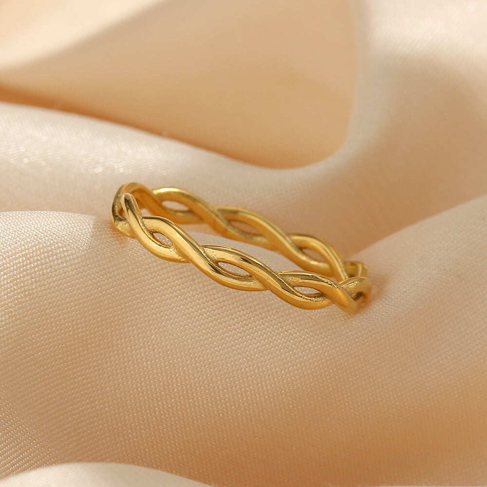 Gold braided ring on a beige fabric background.