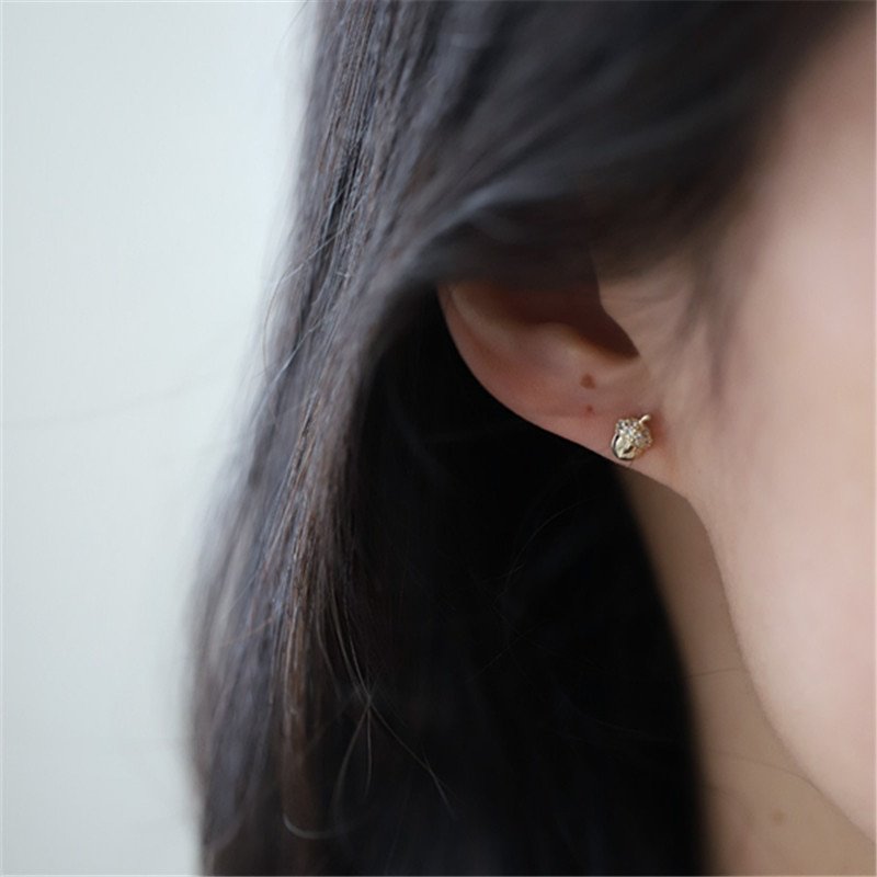 A model wearing the Acorn CZ Studs.