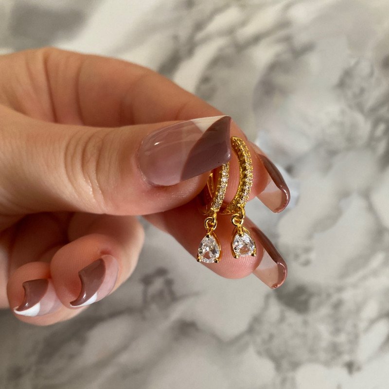 A model holding the Clear Zirconia Teardrop Huggies.