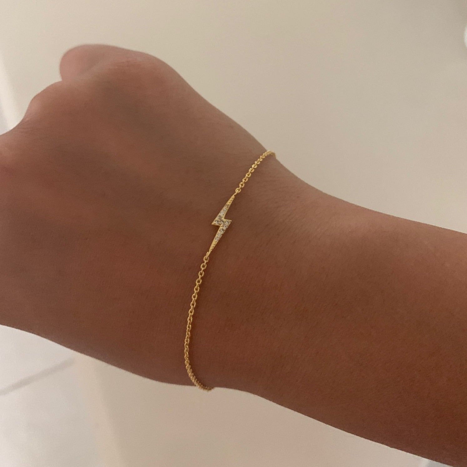 A woman wearing the Lightning Bolt Gold CZ Bracelet.
