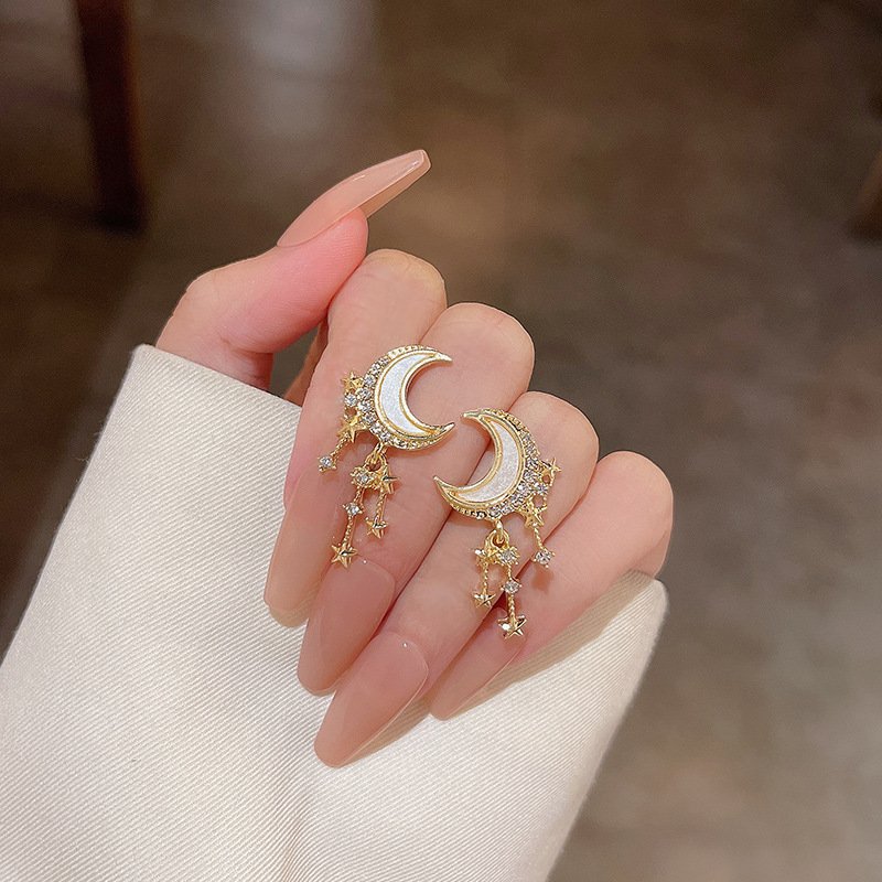 Closeup of the Moon Star Tassel Earrings in Gold.