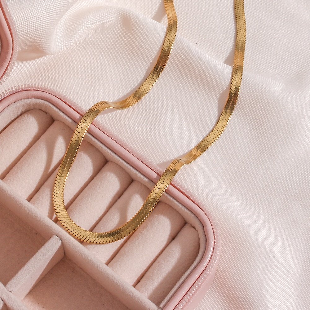 A gold chain necklace in a jewelry box.