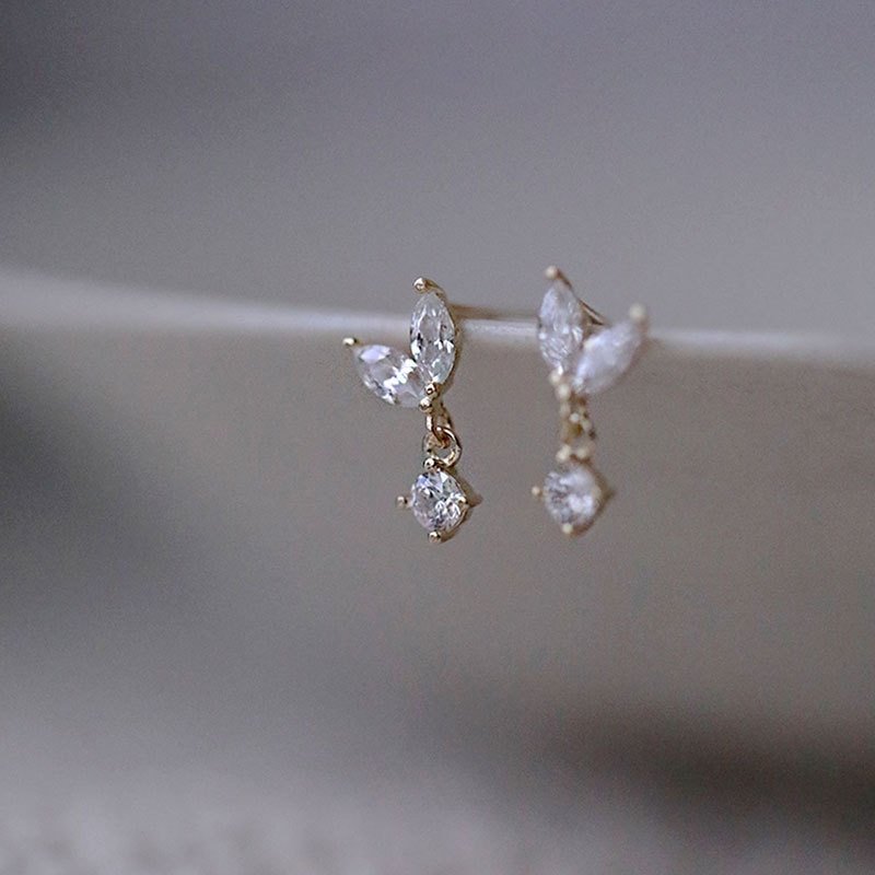 Closeup of dainty gold drop studs.