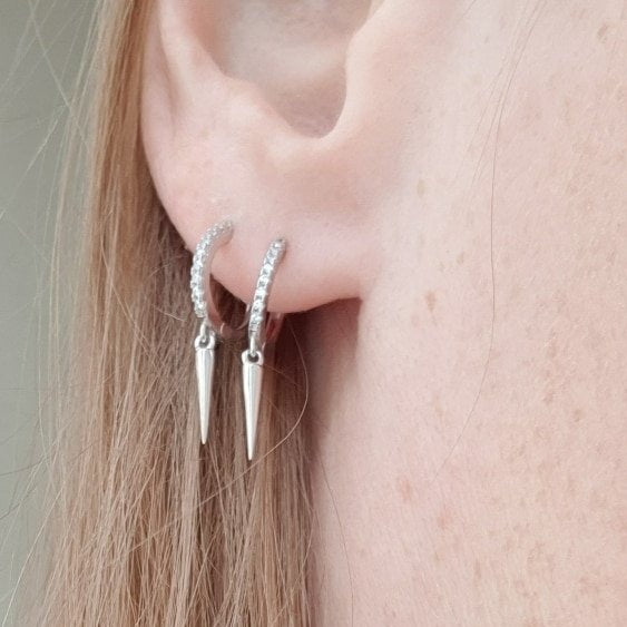 A woman wearing two Spike CZ Huggies.