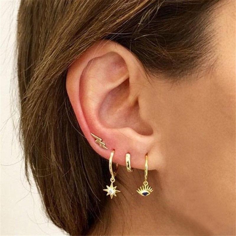 A model wearing multiple gold ear piercings.