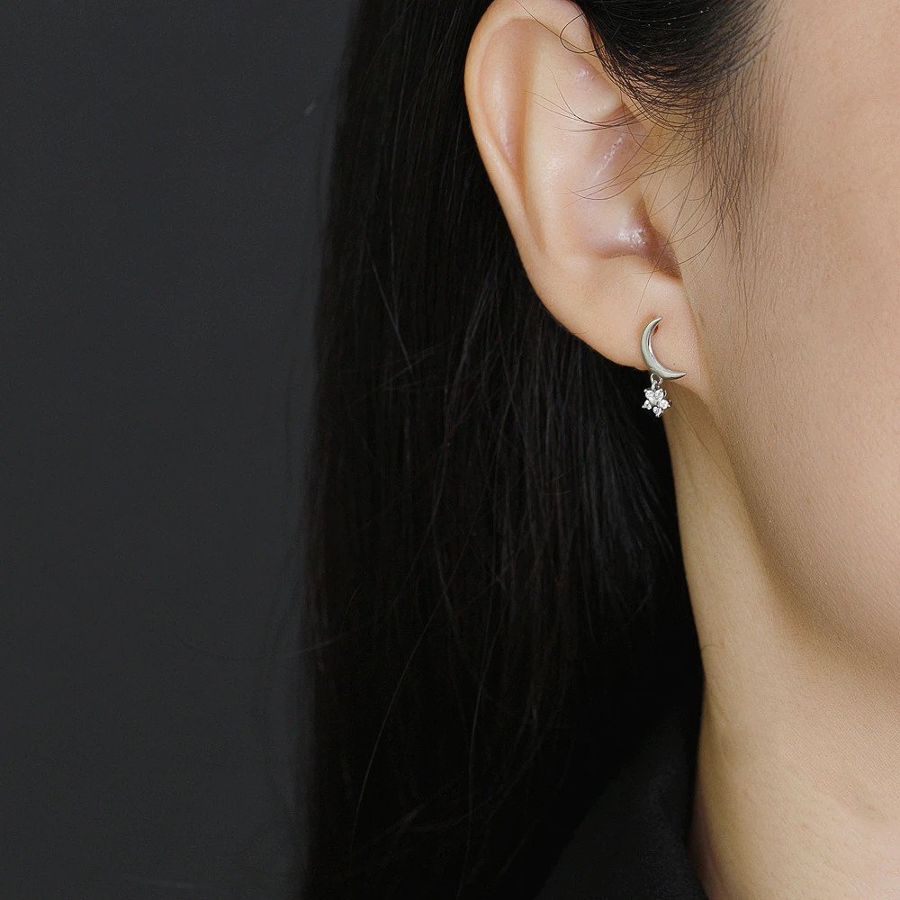 A model wearing the silver Twinkling Moon Earrings.